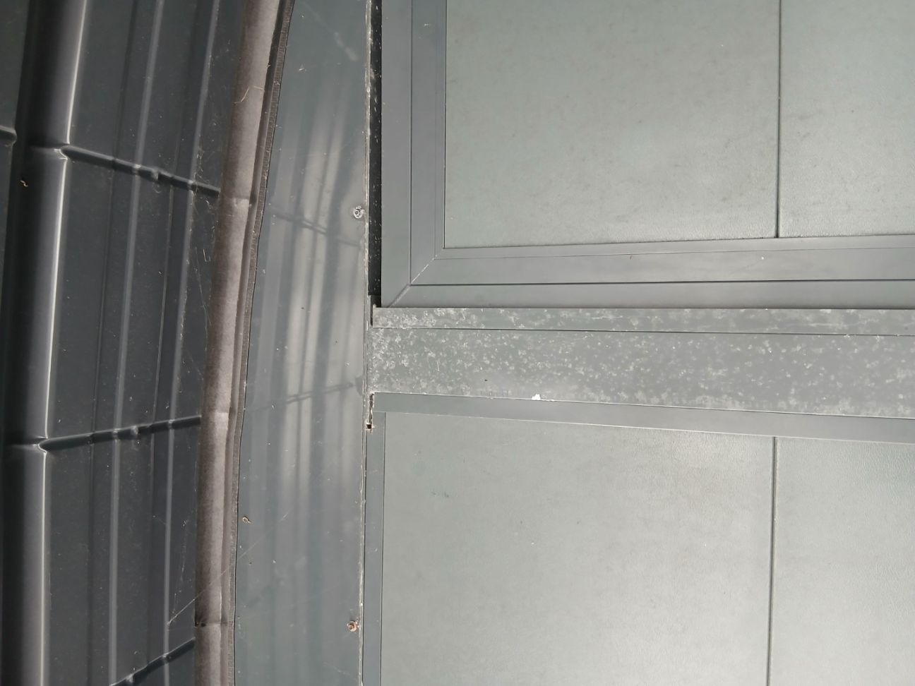 Défaut de laquage de certaines pièces d'un carport : la rugosité importante emprisonne les minéraux contenus dans la pluie, impossible à nettoyer